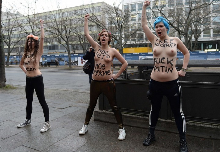 Three topless Femen activists demonstrate in front of the Russian Embassy in Berlin on February 7, 2014. Femen staged the protest on the opening day of the Olympic Games in Sochi to demonstrate against Russian President Vladimir Putin's "dictatorship and oppression of human rights in Russia". AFP PHOTO / PATRIK STOLLARZ